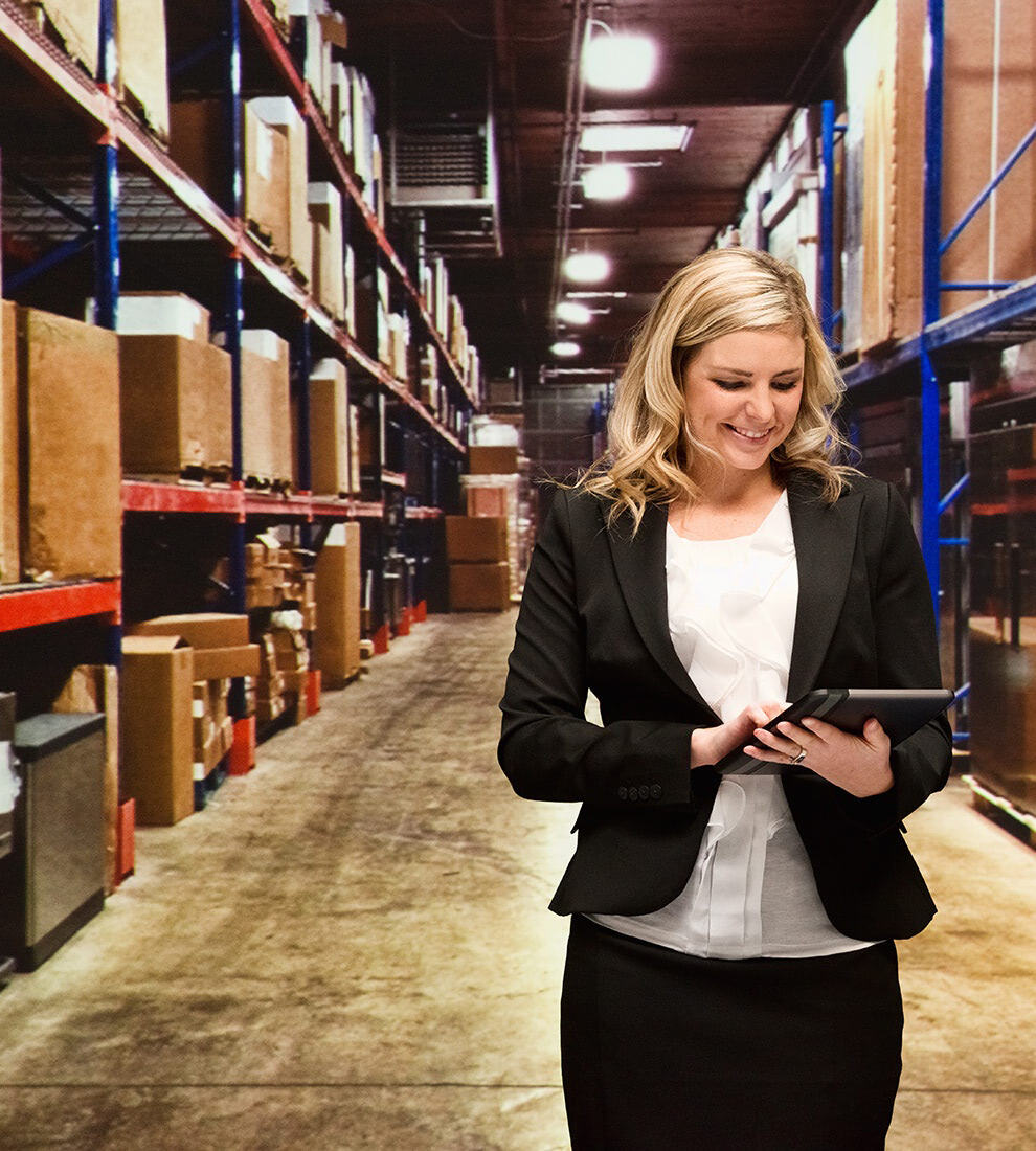 businesswoman-smiling-with-tablet-in-warehouse