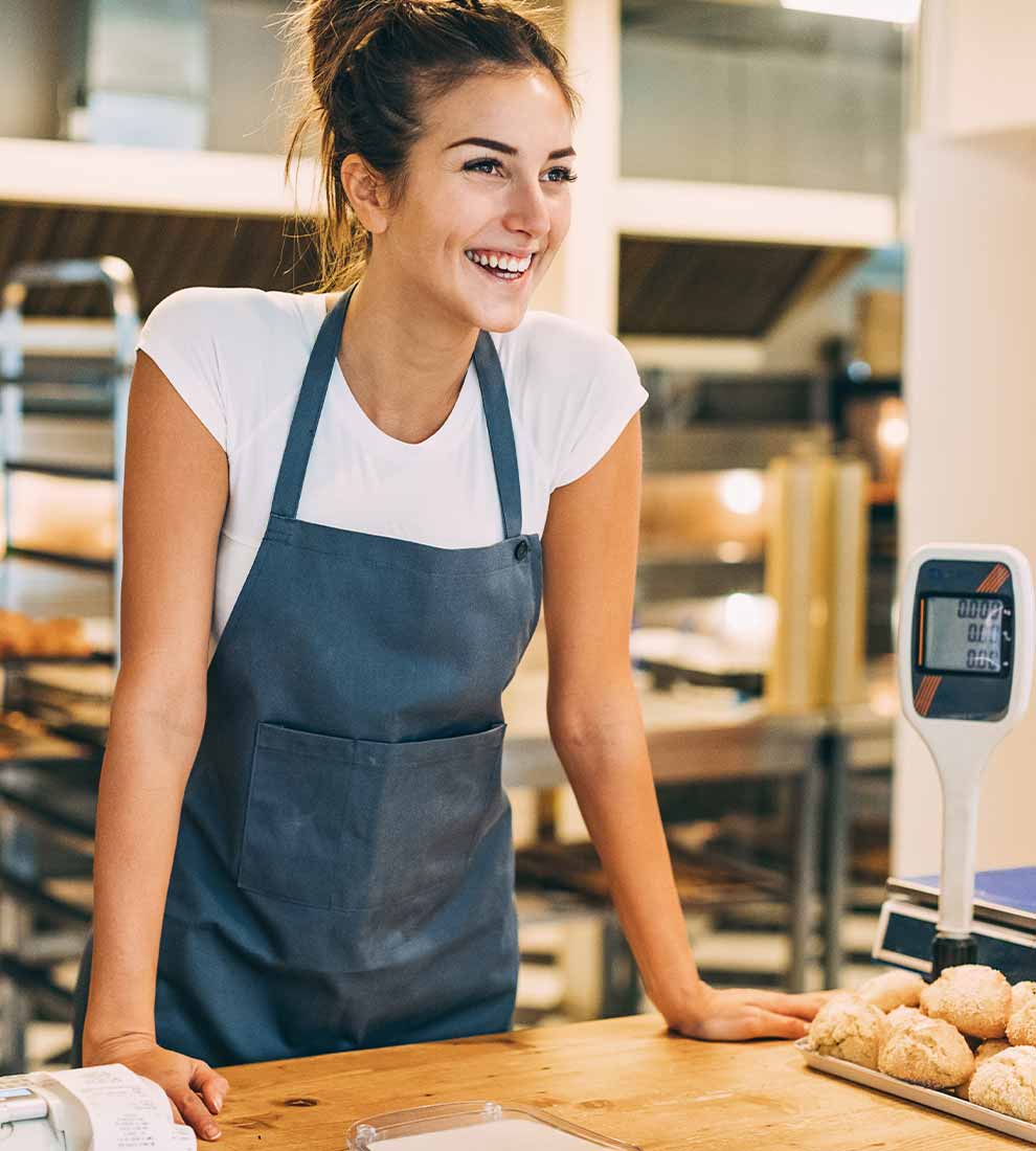 baker-at-bakery-smiling-at-work-station-counter