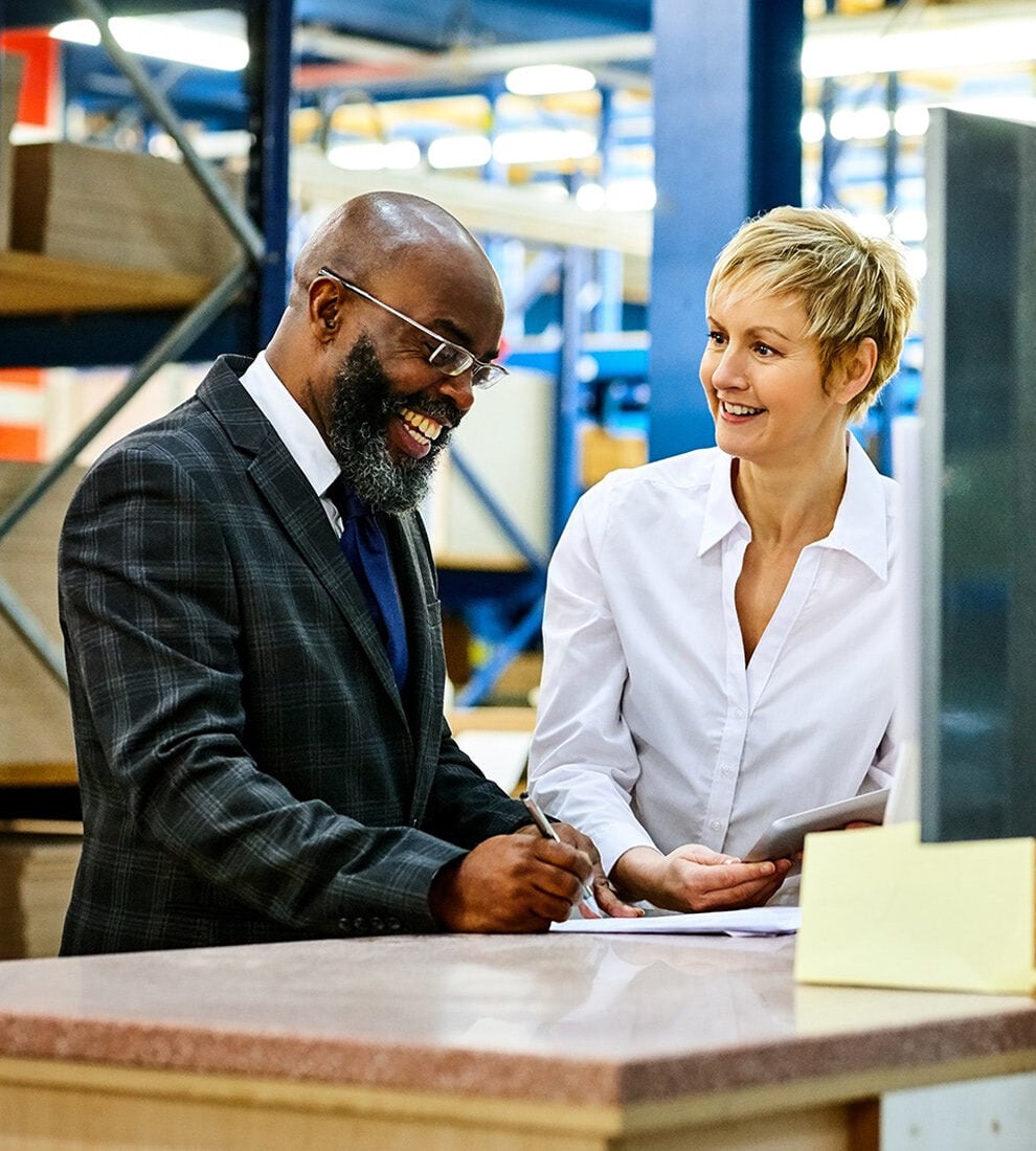 business-people-collaborating-warehouse-smiling