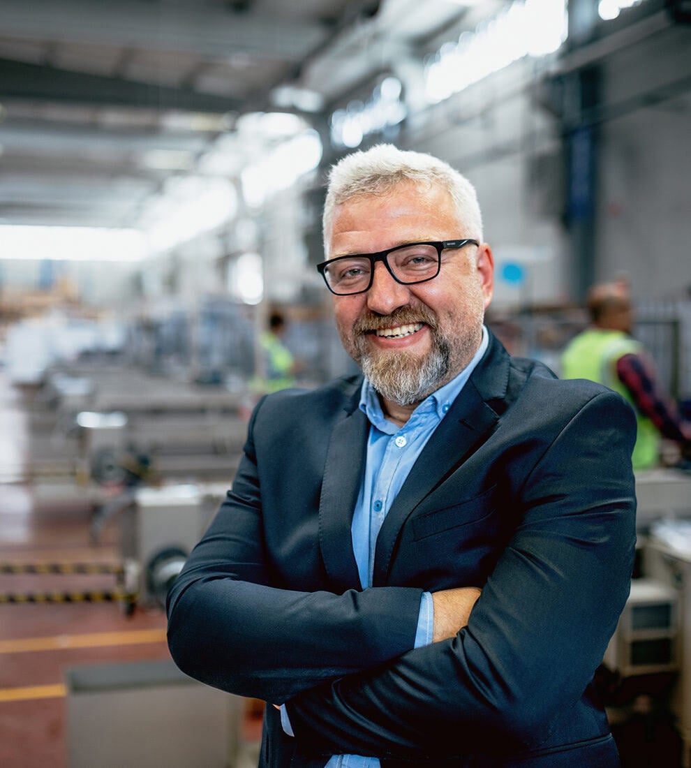 businessman-smiling-arms-crossed-in-factory